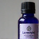 Dettaglio ravvicinato dell'etichetta del flacone di olio essenziale di lavanda, mostrando il logo LuxMen.